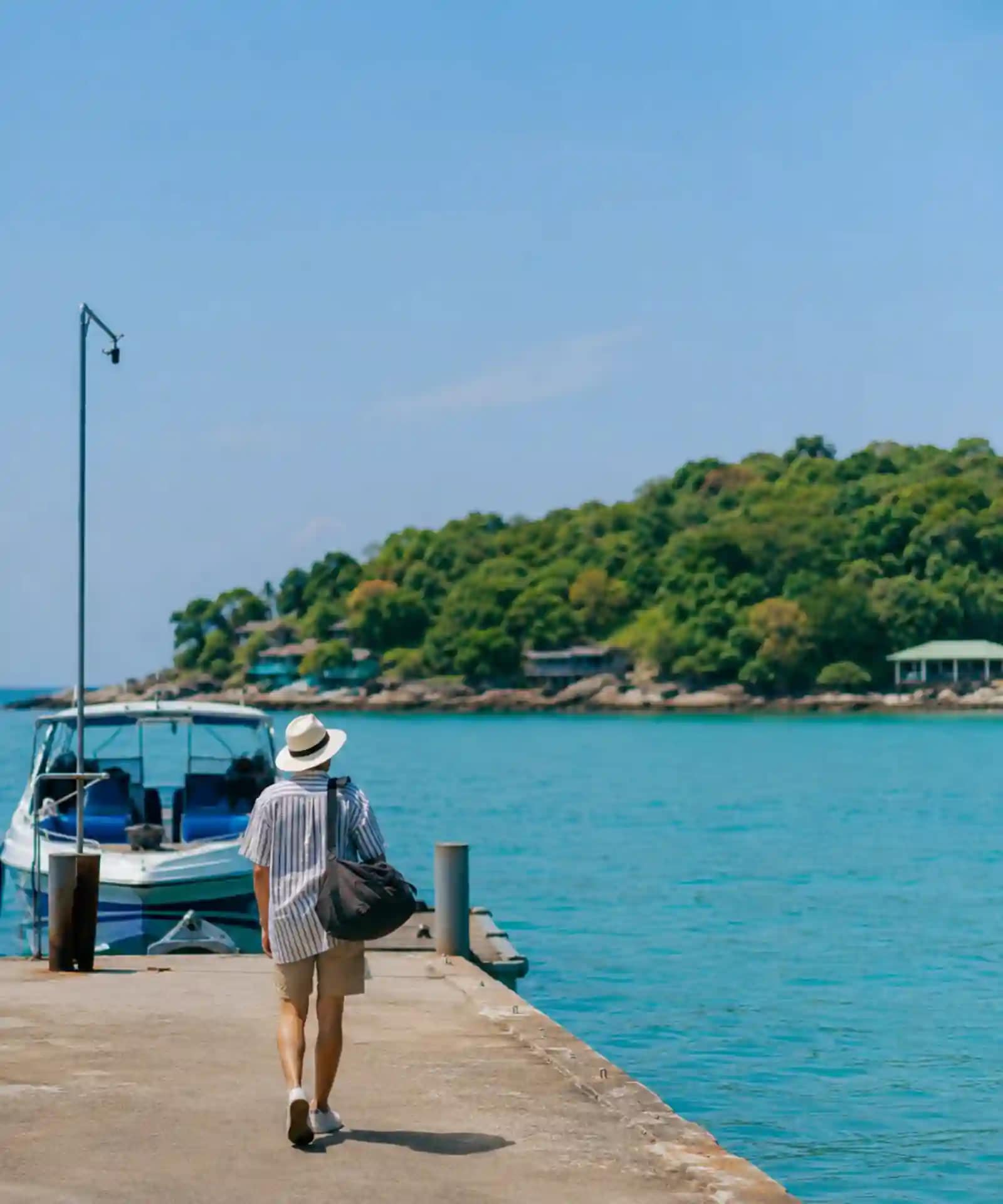 Koh Samet Sun, Sand, and Samet: What You Need to Know Before You Go 2 A traveller arriving at a Koh Samet pier with turquoise water and a green island behind